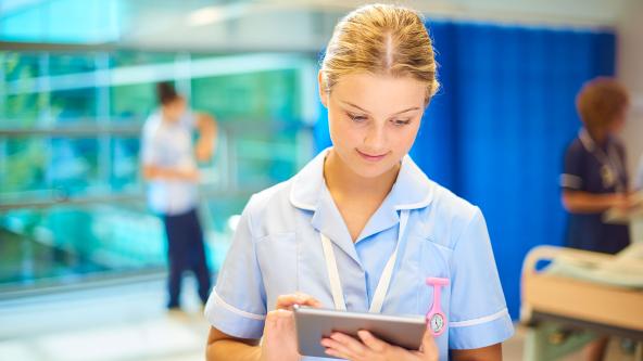 A nurse checking a tablet computer.