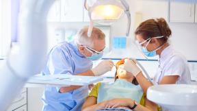 A dental appointment with a dentist, patient and dental nurse.