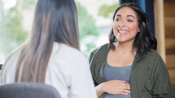 Two pregnant women in conversation.