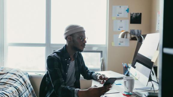 A student at their bedroom desk.