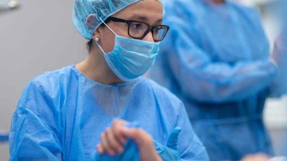 A midwife holding a patient's hand.