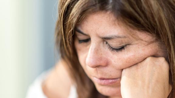 Woman Laying On Bed With Fear And Lower Head, Bruises On Body