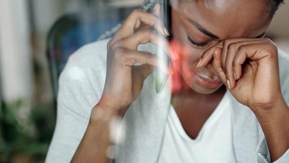 An ill woman making a phone call. 