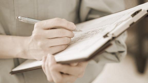 Sepia-toned image of a nurse making notes