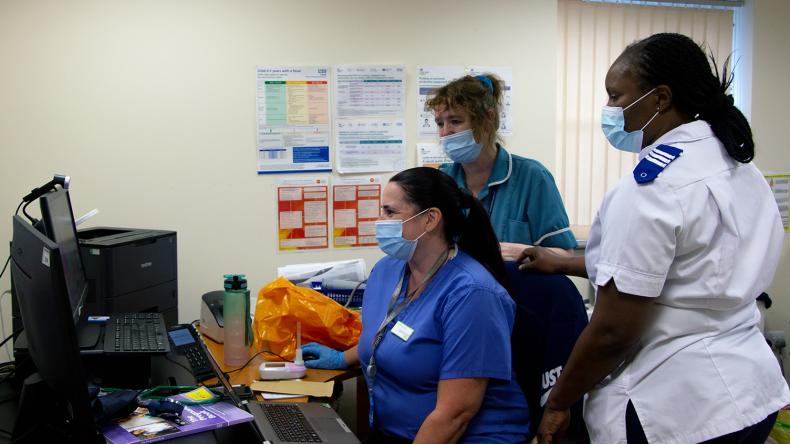 A diverse group of healthcare staff looking at a computer.